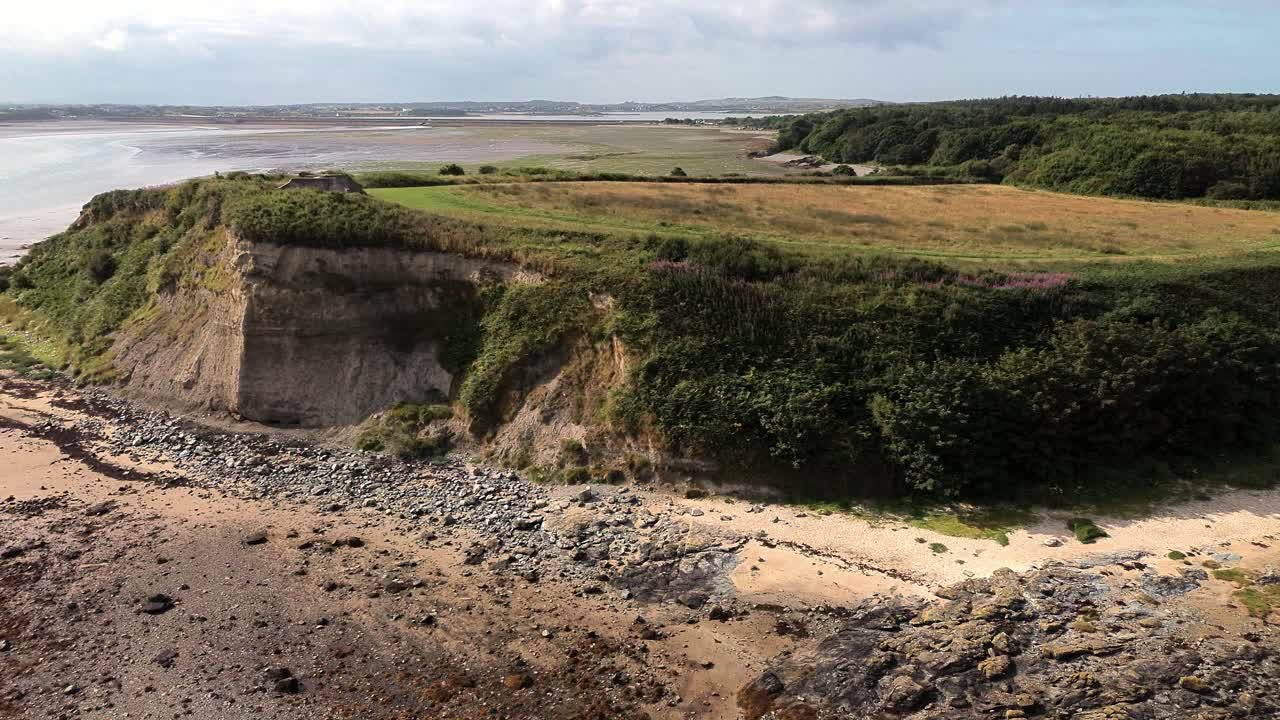 Drone clip of steep meadow headland on top of cliff in Penrhos, North Wales, UK