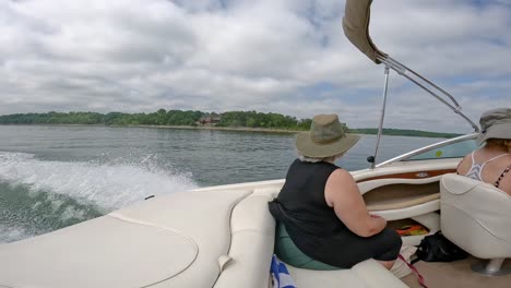 slow motion of woman in rear of cockpit of sports boat this is cruising on table rock lake on a cloudy afternoon