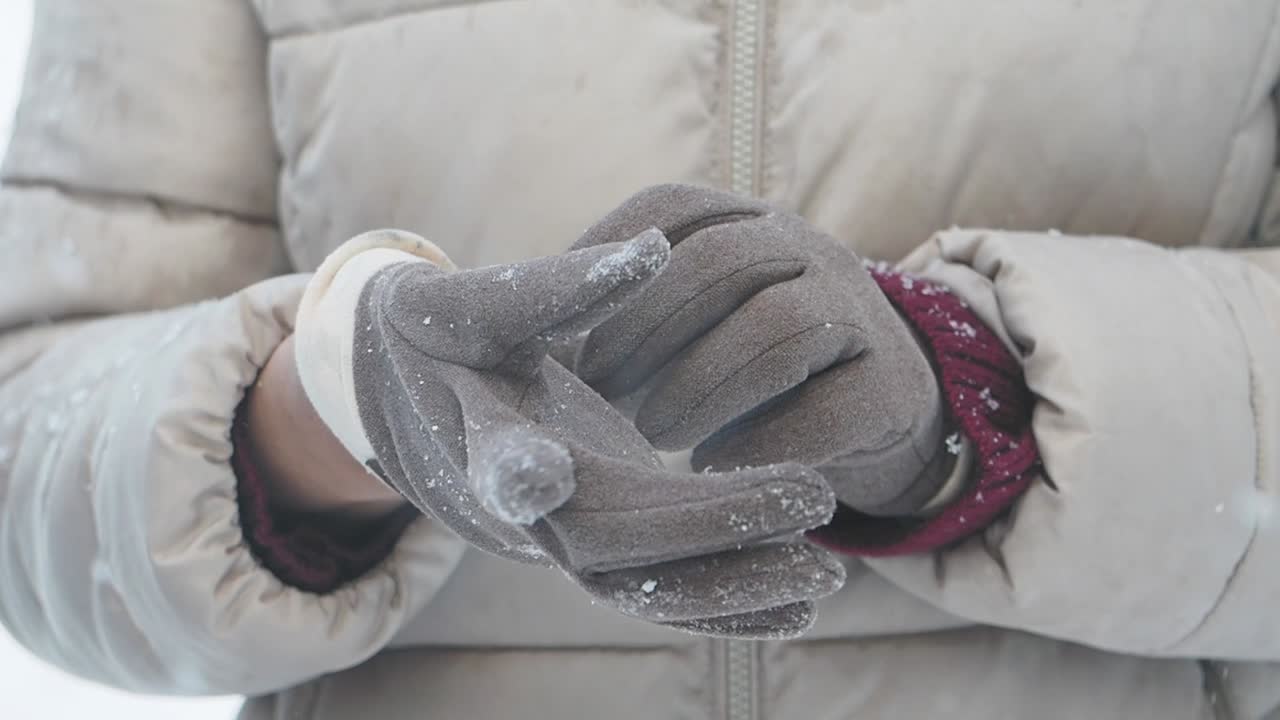Close-up of gloved hands in snowy winter setting
