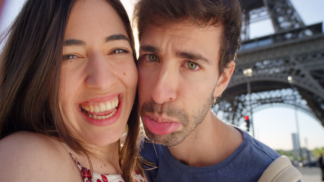 una pareja riendo en la torre eiffel.