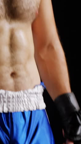 un boxeador de pie contra un fondo negro