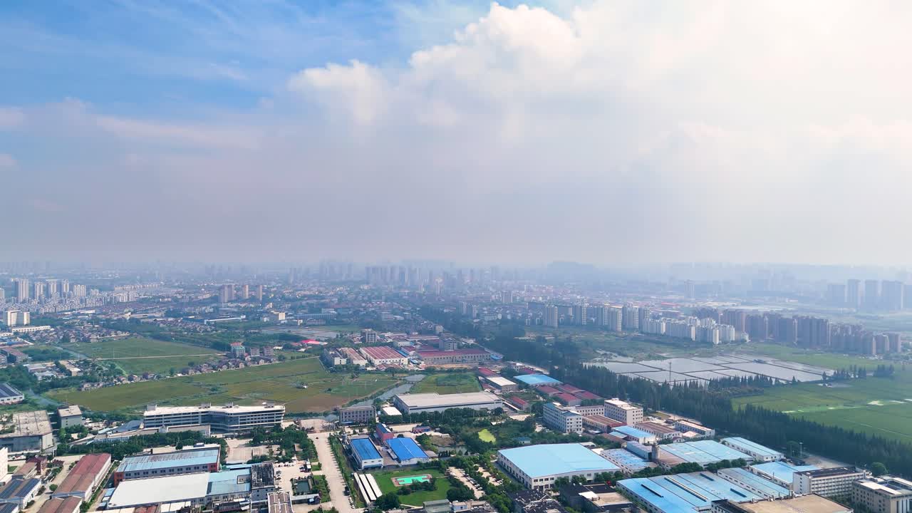 Aerial view of the outskirts of Danyang City in Jiangsu Province, China, during the daytime, showcasing a blend of urban and rural landscapes of developed areas.