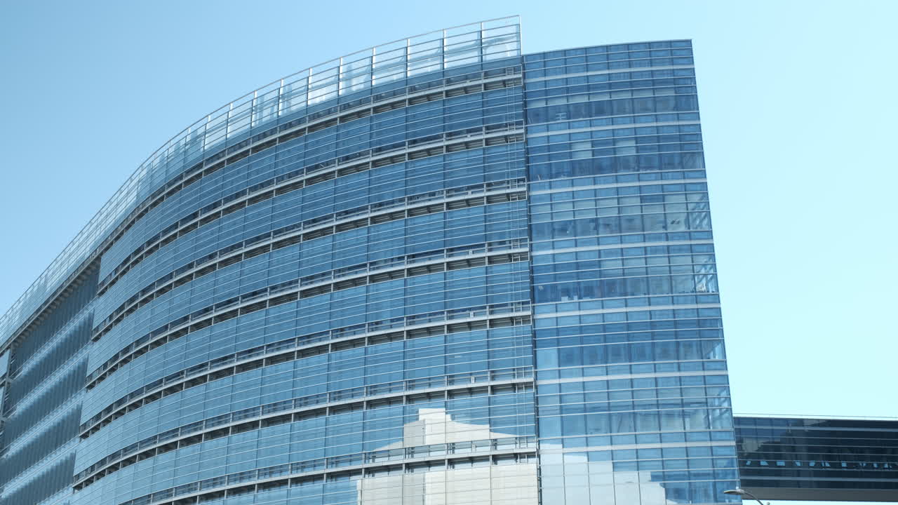 Modern Glass Building Facade Against Clear Blue Sky