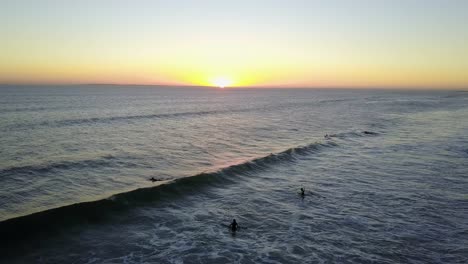 aerial people surfing during sunset golden hour on cape town beach