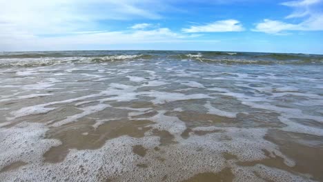ocean waves crashing on sandy beach slowmotion shot