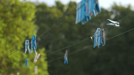 Clothespins-and-empty-Clothes-line-on-blur-background-in-yard