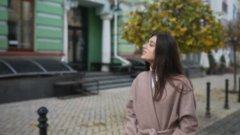 mujer caminando por una calle de la ciudad en otoño