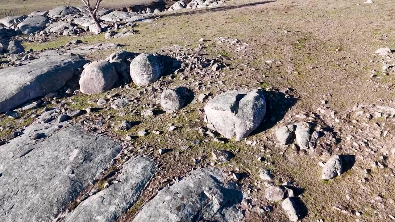 Luftfoto av steinete terreng og sparsomt gressland