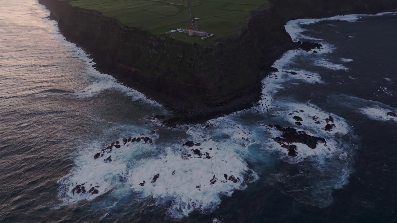 vista aérea del faro de albarnaz inclinado desde el acantilado en la isla de flores, azores