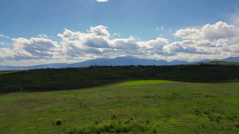 drone establishing of olympus mountain range under clear skies, open field and mythology landscape