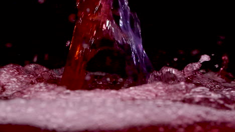 waves of red energy drink for sports mixture with bubbles and foam