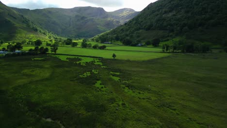 Shadowed-valley-with-reveal-showing-mountains-and-sunlight-patches-moving-across-valley-floor