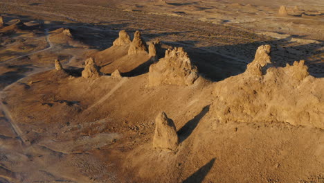 sol dorado bajo que proyecta una sombra dramática sobre el paisaje que rodea los pináculos de trona