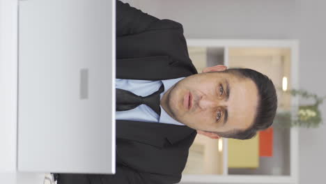 vertical video of home office worker man looking emotional at camera.