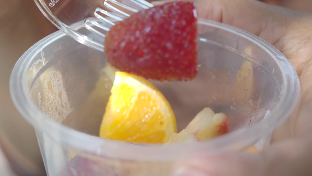Person eating fruit salad
