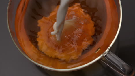 la leche que se vierte en la taza de té