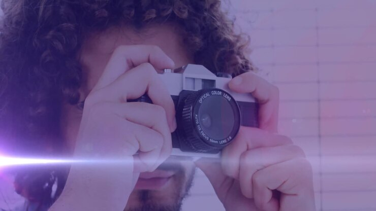 Světelný bod proti afroamerickému fotografovi fotícímu s digitálním fotoaparátem.