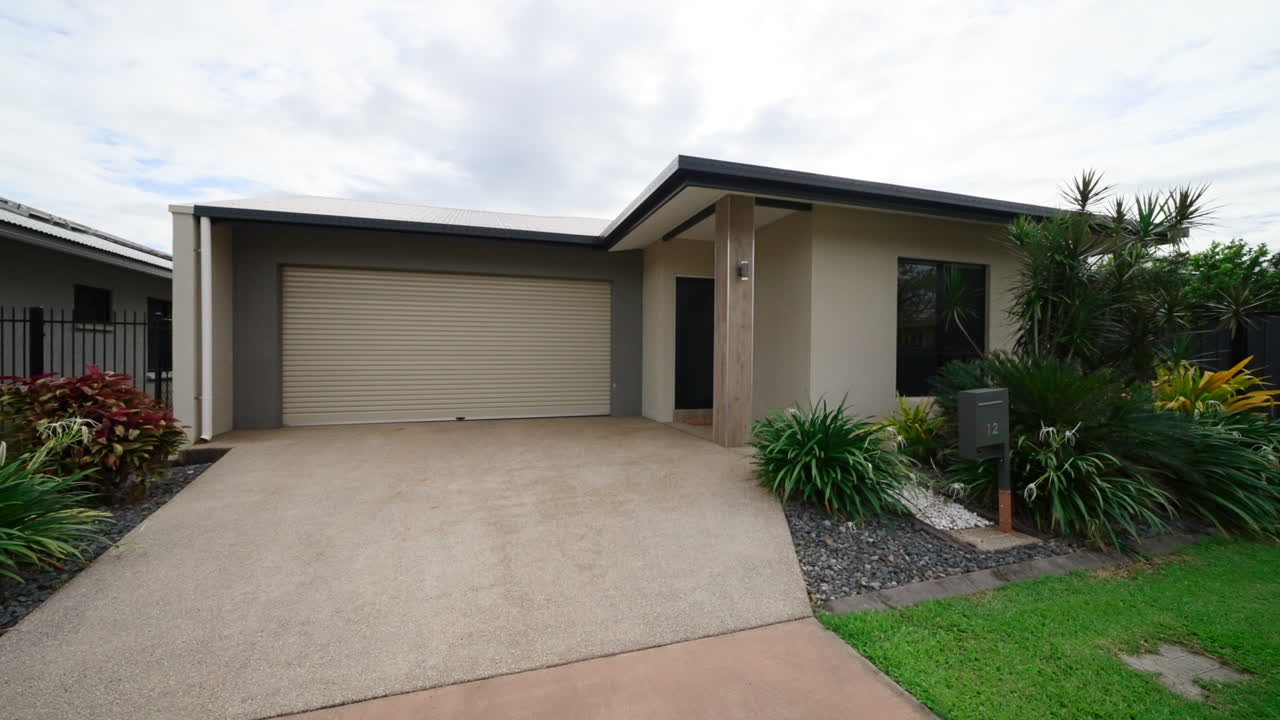Front exterior view of a modern house with a garage and garden