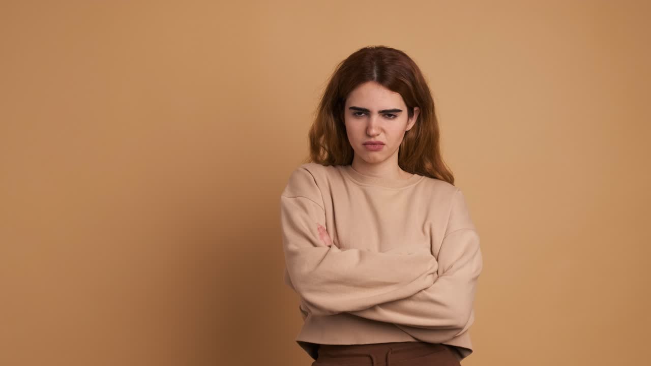 Angry young woman crossing arms and looking at camera