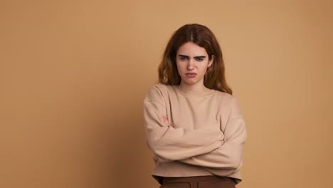angry young woman crossing arms and looking at camera