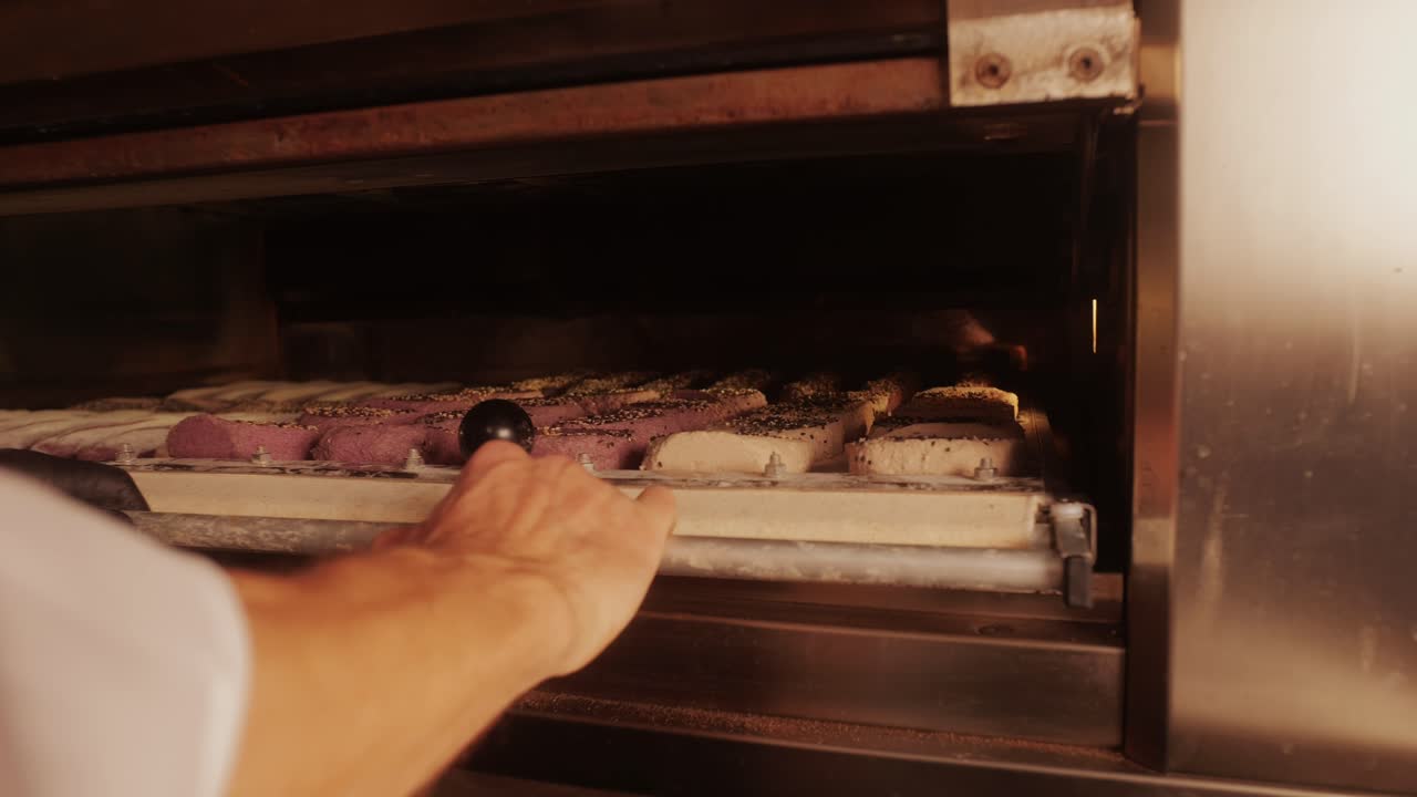 Primo piano di un panettiere che prepara diversi tipi di panini artigianali freschi e baguette usando una ricetta tradizionale. Un giovane impasta l'impasto. Il pane artigianale è prodotto da panettieri esperti che utilizzano ingredienti naturali e di alta qualità. Cibo con benefici per la salute e il gusto. Panificio e mercato.
