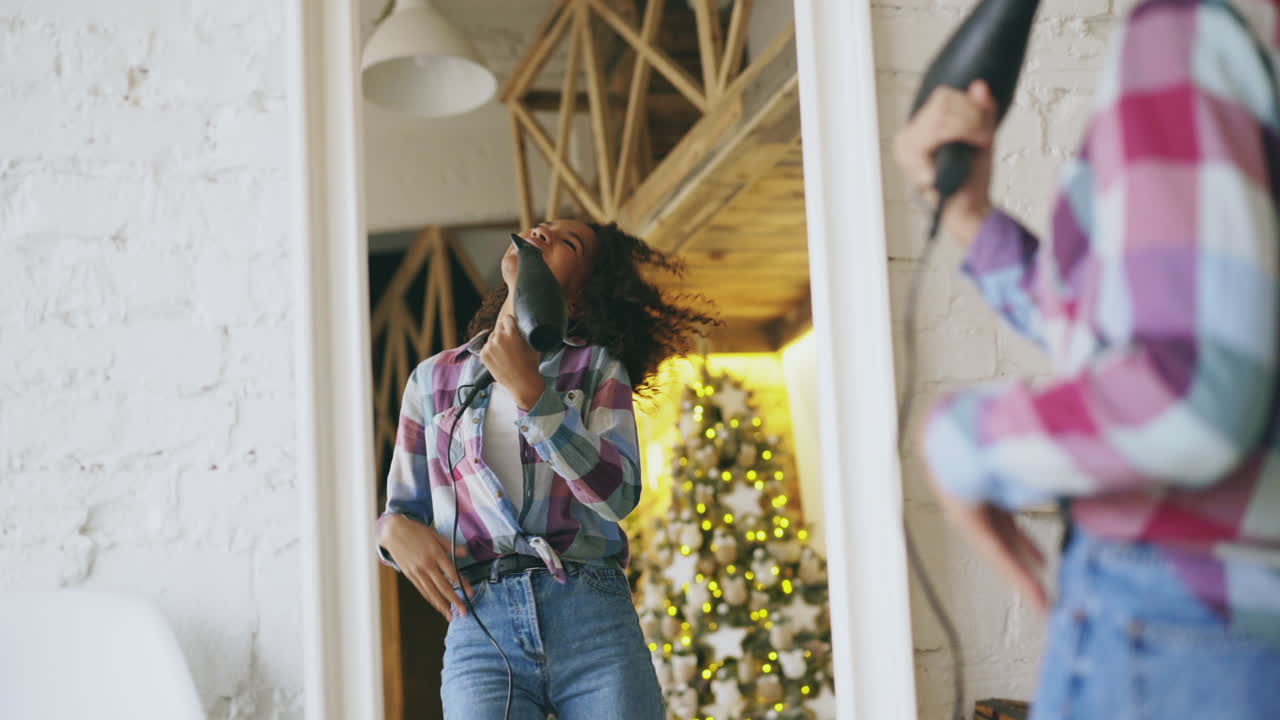 Teenage Girl Singing with Hair Dryer as Microphone at Christmas
