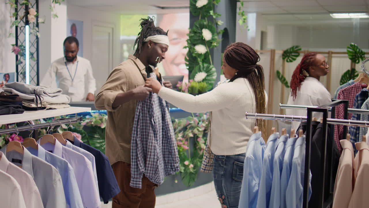 부부가 가게에서 값싼 옷을 사고 있습니다.