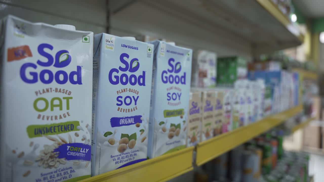 Customer choosing vegan plant based soy and oat milk beverage unsweetened tetra pack, Selective focus, Closeup