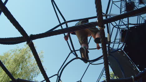 niño escalando en un juego de cuerdas de gimnasia de la jungla