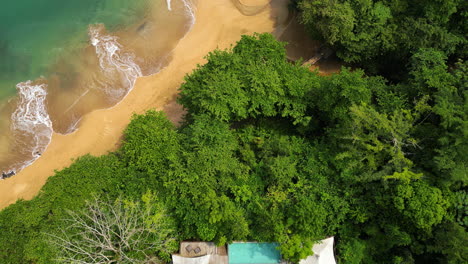 aerial tilt reveal of the sundy praia lodge hbd principe and the coastline