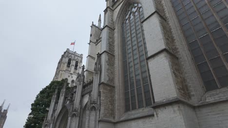 Low angle view of St. Michael and St. Gudula Cathedral in Brussels, Belgium, highlighting gothic architecture and stained glass windows on a cloudy day