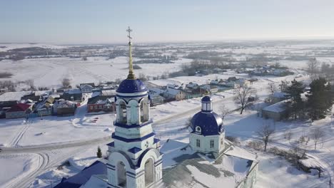 aerial view of a snowy russian village with churches