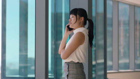 asian-business-woman-using-smartphone-corporate-sales-executive-chatting-to-client-financial-advisor-negotiating-deal-sharing-expert-advice-having-phone-call-in-office-looking-out-window