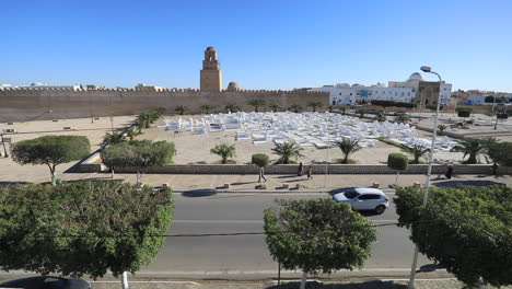 a historic mosque and open plaza in tunisia viewed from above under a clear blue sky