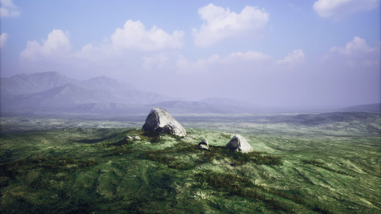 Vast green landscape with distant mountains under a blue sky in daylight