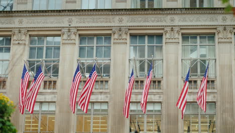 a row of american flags on the facade of the administrative building in new york