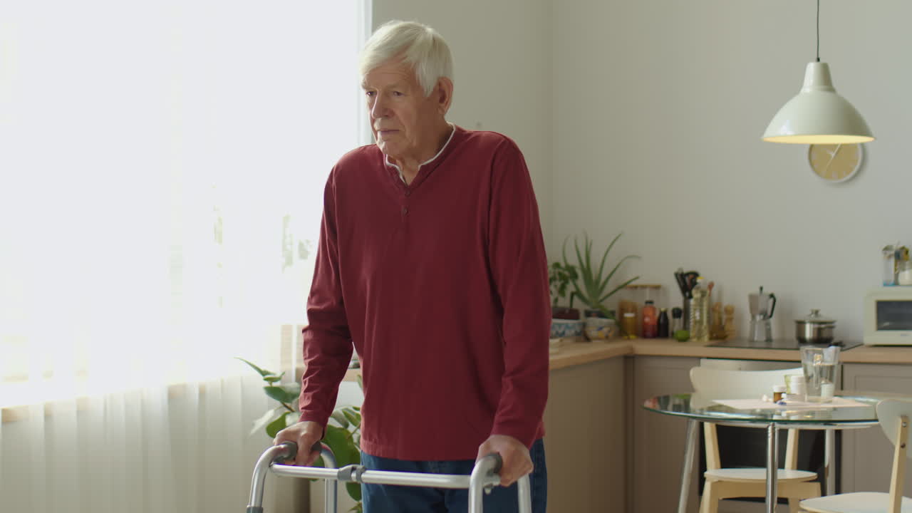 Eldre mann bruker rullator hjemme