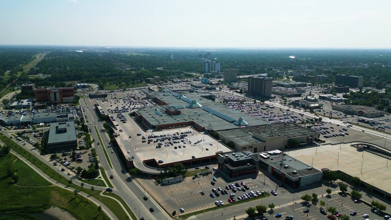 Statisk luftfoto-timelapse af trafik, køretøjer og kommerciel aktivitet omkring CF Polo Park indkøbscenter i Winnipeg på en lys sommerdag