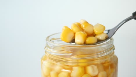 close-up of a jar of canned corn with a spoon
