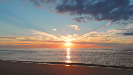 Una-Marea-Baja-Tranquila-En-La-Playa-Cerca-De-La-Barrera-De-Marejada-En-El-Suroeste-De-Los-Países-Bajos,-Durante-La-Puesta-De-Sol