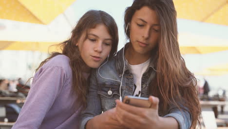 Two-Teenage-Friends-Share-Headphones-And-Listen-To-Music-From-The-Same-Device-1