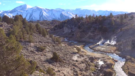 establishing shot of a hot spring and river flowing through the eastern sierra nevada near mammoth hot springs