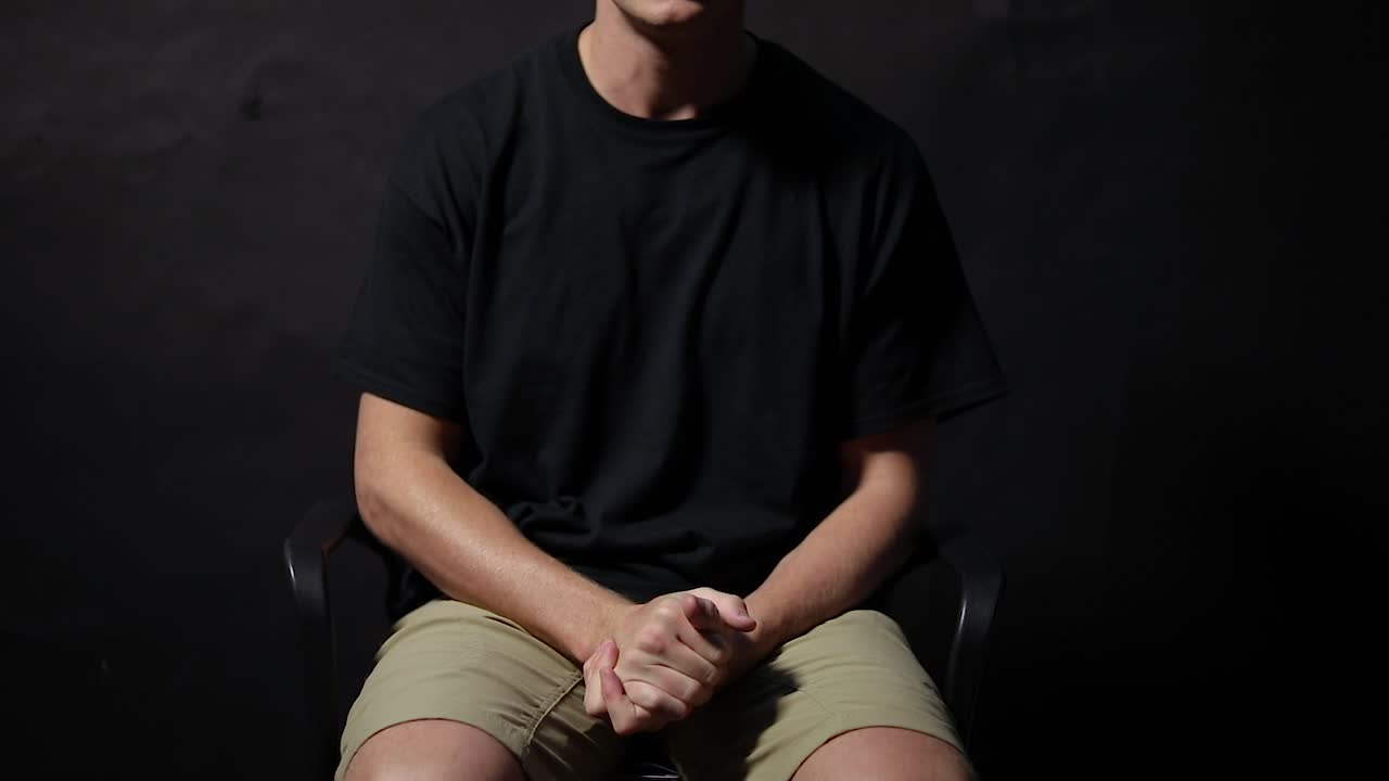 foto de un hombre sentado en una silla frotándose las manos con ansiedad