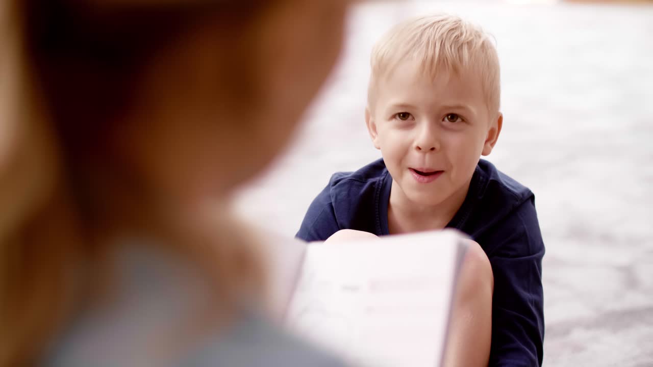 Un bambino che parla con la maestra all'asilo.