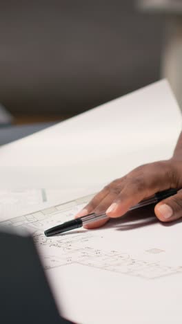 vertical video african american contractor examine architectural blueprints plans on table