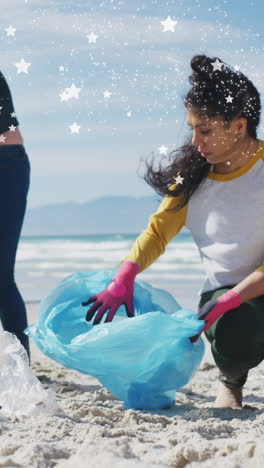 animation of stars over diverse female and male volunteers picking up rubbish on beach