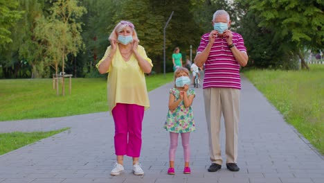 pareja mayor abuela abuelo con nieta usando máscara de protección médica coronavirus