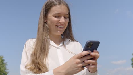 Beautiful-Woman-Smiling-and-Texting-on-Phone,-Cinematic-Flare-Shot