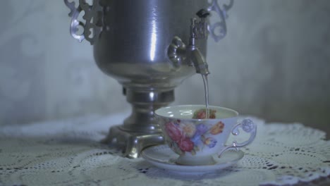 pouring hot water from a vintage electric metal tea kettle into a gorgeous cup