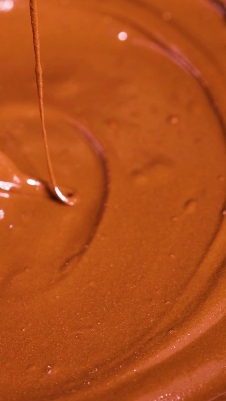 Cucchiaio che mescola cioccolato cremoso in una ciotola
